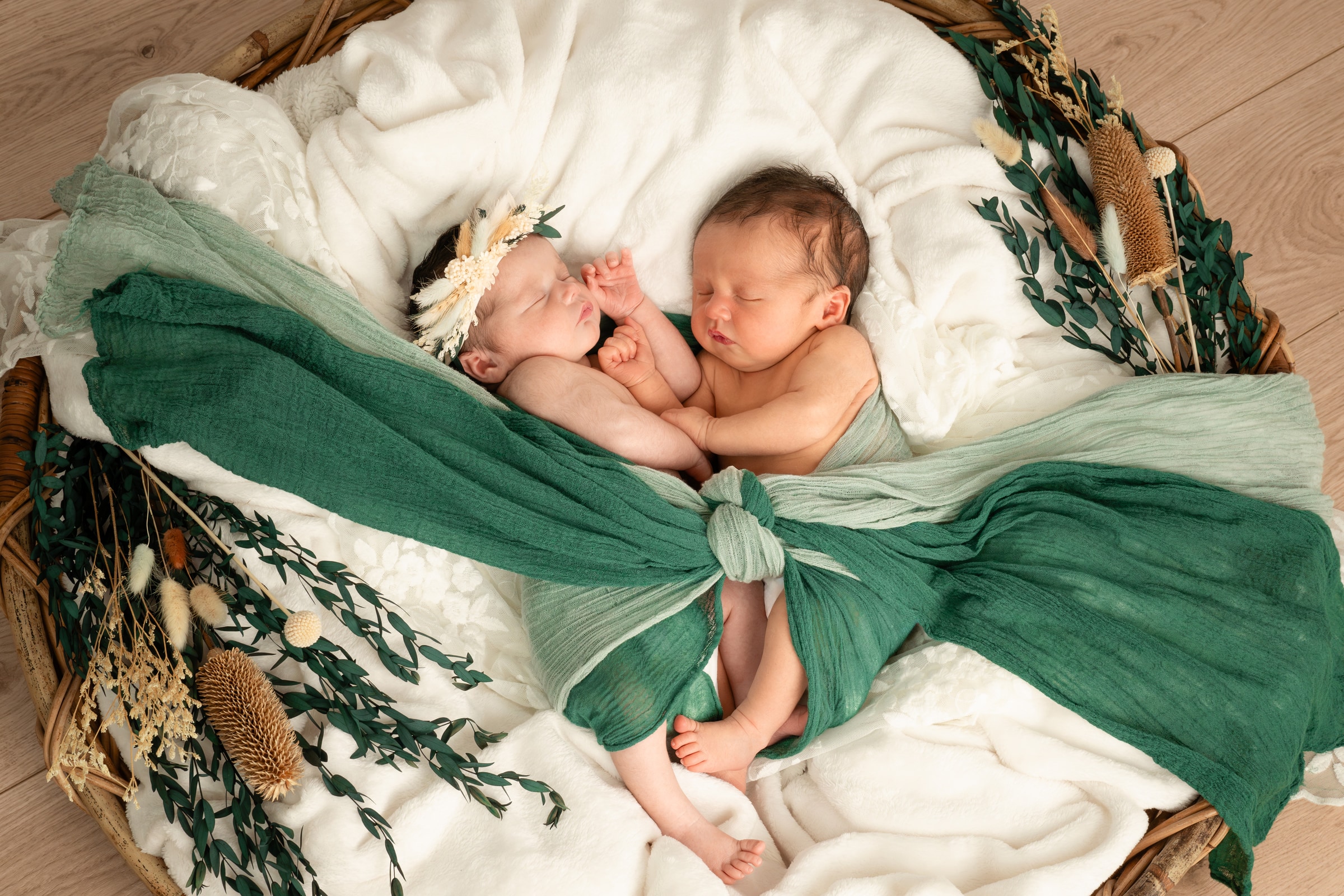 A peaceful newborn baby curled in a soft neutral wrap, photographed at the Shelby Vilate Studios Coorparoo studio in Brisbane
